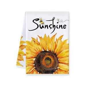 Close-up of white decorative kitchen towel with sunflower pattern and Sunshine text