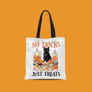 Close-up of Halloween canvas tote bag with black cat, pumpkin print, and festive lettering