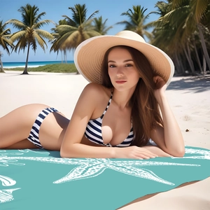 Detail showing bikini with stripes, woven beach hat and starfish printed mat on sand