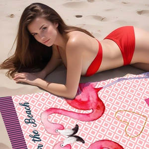 Detail of soft microfiber beach towel featuring pink flamingo print and on the Beach text