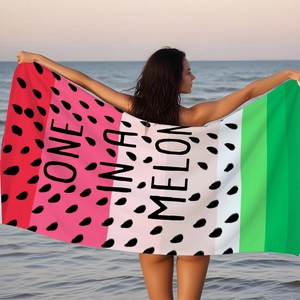 Watermelon microfiber beach towel with One In A Melon print shown in a scenic beach sunset