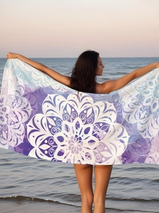 Microfiber beach towel with purple and blue mandala print shown in sunset beach setting