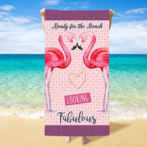 Microfiber beach towel with flamingo print and geometric diamond pattern on sunny shore