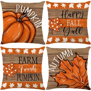 Detail view of four linen autumn pillow covers with watercolor pumpkins and maple leaf prints