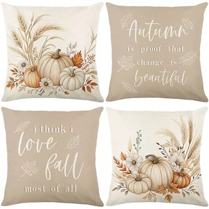 Close-up of four linen autumn pillow covers featuring watercolor pumpkins and fall foliage