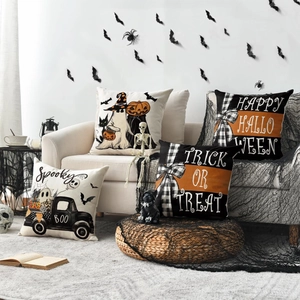 Set of 4 Halloween throw pillow covers with pumpkin ghost and truck patterns on a white sofa