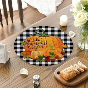 Detail of buffalo plaid table mat with pumpkins, maple leaves and grateful text