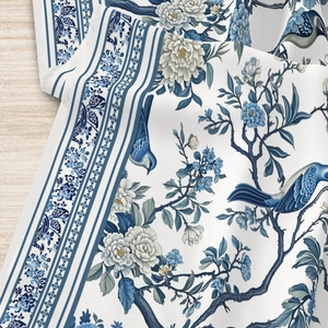 Detailed view of Chinoiserie blue floral and bird patterns on textured fabric tablecloth