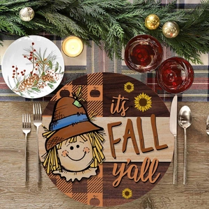 Macro view of round linen placemat featuring scarecrow and It's Fall Y'all text