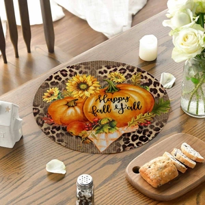 Detail of linen placemat with pumpkins and Happy Fall Y'all text on wooden table