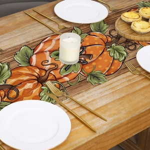 Macro detail of autumn pumpkin table runner with rustic wood print and neat stitching
