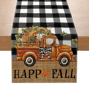 Detail of fall table runner featuring buffalo plaid and pumpkin truck with Happy Fall text