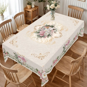 Detail of elegant rectangular tablecloth with pink rose print and golden scroll patterns