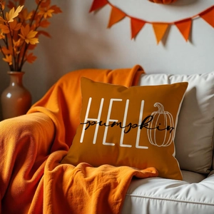 Close-up of Hello Pumpkin square pillowcase on sofa with autumn harvest home decorations