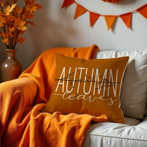 Close-up of orange autumn pillow cover with white text and matching knit blanket