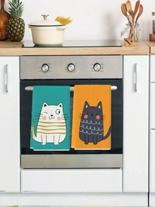 Close-up of cute cartoon cat dish towels hanging on a kitchen oven handle for drying