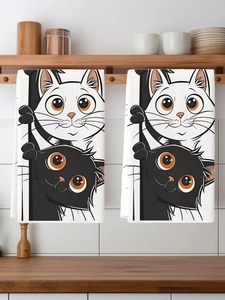 Detail view of two white kitchen towels featuring cute black and white cat illustrations