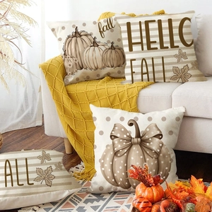 Set of four autumn pumpkin pillow covers with maple leaves and polka dots on a sofa