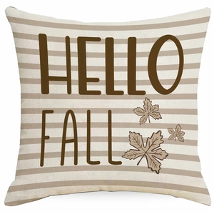 Macro view of linen pumpkin pillowcase with brown HELLO FALL text and maple leaf detail