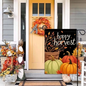 Garden flag with pumpkins and maple leaves displayed on a rustic porch for autumn harvest