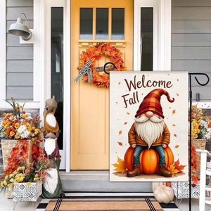 Close-up of autumn garden flag with gnome and pumpkin design on a cozy porch display