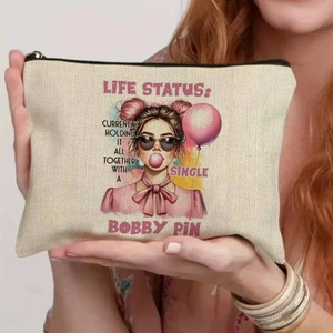 Linen makeup bag with retro girl illustration held by a hand, showing fabric texture