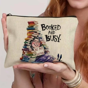 Detail of canvas makeup bag held by hands with humorous Booked and Busy book illustration