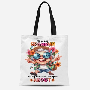 Detail of white canvas tote bag featuring a funny grandmother cartoon print and black straps