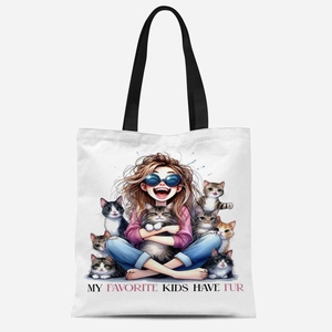 White canvas tote bag with black handles featuring cat illustrations and fur kids quote