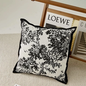 Detail of chenille pillow cover featuring black tree patterns and velvet border trim