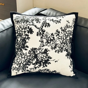 Detail of luxury chenille pillowcase with artistic black tree pattern on leather sofa
