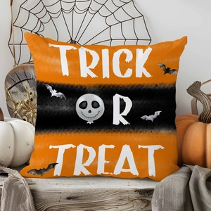 Detail of Trick or Treat Halloween pillow case with skull and bat print on wood surface