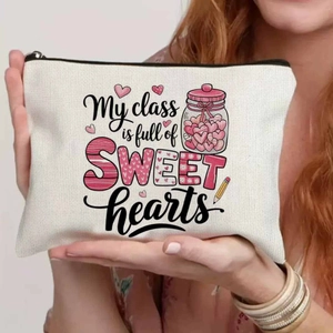 Detail of canvas makeup bag with sweet hearts print held by hand for scale