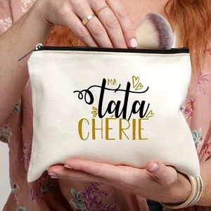 Detail of canvas makeup bag being used by a hand to store brushes and cosmetics