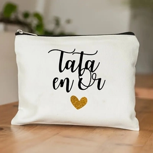 Close-up of white canvas makeup bag with Tata en Or text and golden sequin heart