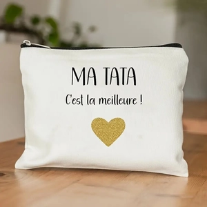 White canvas makeup bag featuring French text and gold glitter heart on a wooden surface