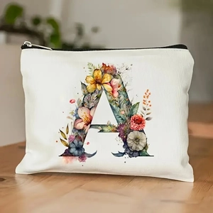 Canvas makeup bag featuring floral letter A print and black zipper on wooden table