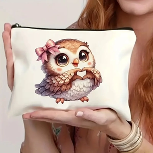 Close-up of cute owl makeup bag with pink bow and zipper held by hands in a lifestyle shot
