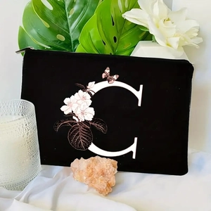 Detail of black pouch with floral letter C print on high-quality velvet fabric