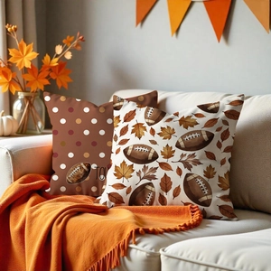 Set of two Thanksgiving football and maple leaf cushion covers on a cozy sofa