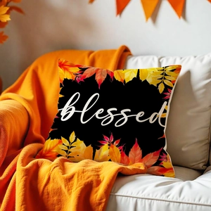 Close-up of fall pumpkin maple leaf pillow cover with white blessed text on a sofa