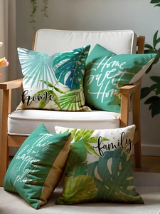 Detailed view of four tropical leaf pillow covers on a white chair with family-themed text