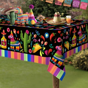 Close-up of Mexican fiesta tablecloth featuring tacos and pinatas on an outdoor wooden table