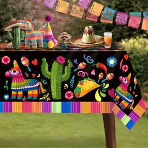 Detail of Mexican fiesta tablecloth featuring colorful cactus and taco patterns on black background