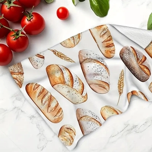 Detailansicht eines Küchentuchs mit Aquarell-Brotmustern auf weißem Baumwollstoff