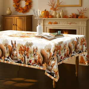 Detailed view of autumn tablecloth featuring squirrel and maple leaf patterns with gingham edges
