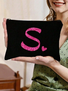 Detail einer schwarzen Segeltuch-Kosmetiktasche mit rosa Pailletten-S und Herzmotiv