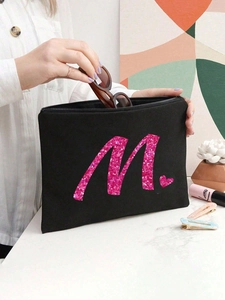 Detail der schwarzen Make-up Tasche aus Canvas mit rosa Pailletten Buchstabe M für Brillen