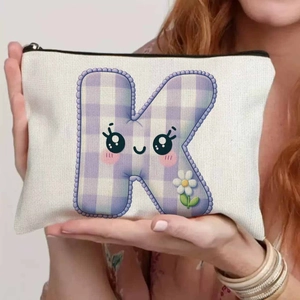 Detailed close-up of a white canvas pencil pouch with cartoon letter K pattern and zipper