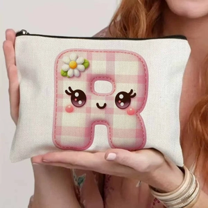 Detail of canvas bag with cute pink letter R and daisy embroidery being held by hand